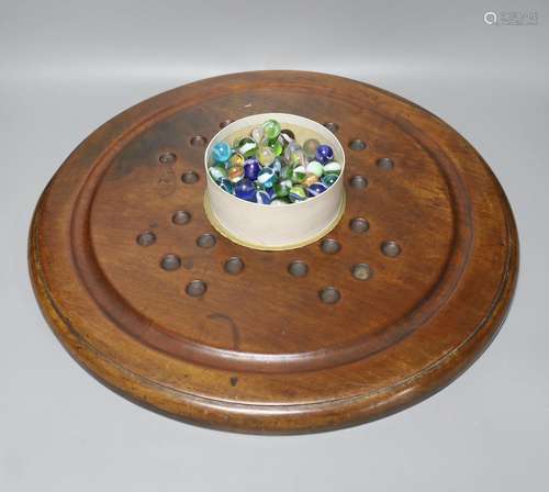 A collection of glass marbles and a mahogany solitaire board...