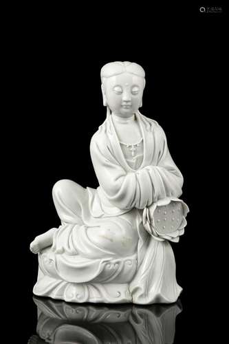 A MOLDED DEHUA BLANC DE CHINE MODEL OF A SEATED GUANYIN WITH...