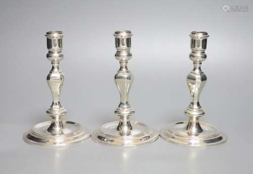 A modern set of three 18th century style cast silver candles...
