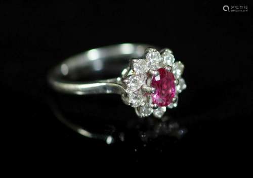 A white gold, ruby and diamond set flower head cluster ring,...