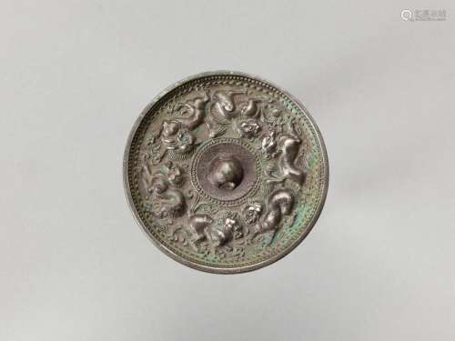 A CIRCULAR BRONZE MIRROR WITH ANIMALS