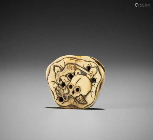 A STAG ANTLER NETSUKE WITH SKULL AND LOTUS