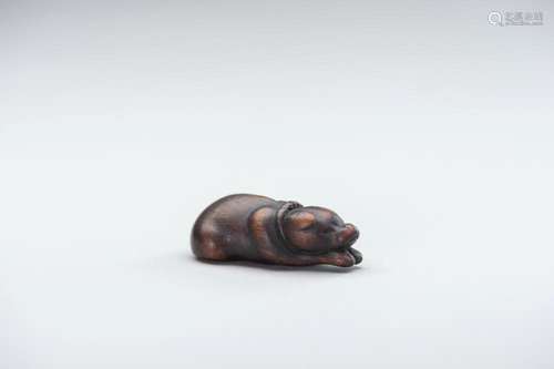 A CHARMING OLD WOOD NETSUKE OF A RECLINING DOG