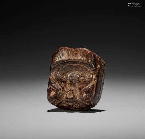 AN AMUSING AND UNUSUAL KIRI (PAULOWNIA) WOOD MASK NETSUKE OF...