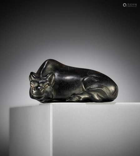 MASAYOSHI: AN EBONY NETSUKE OF A RECUMBENT OX