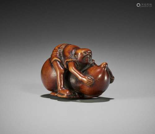 AN EDO SCHOOL WOOD NETSUKE OF A MAN RIDING A GIGANTIC GOURD