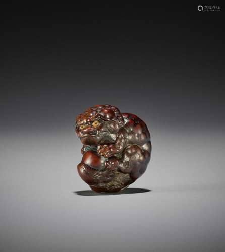 TOYOKAZU: A FINE WOOD NETSUKE OF A SHISHI PLAYING WITH A BAL...