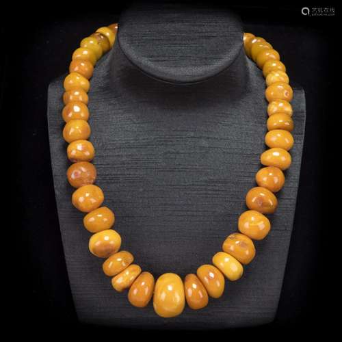 A STRAND OF NATURAL-SHAPED BEADED BEESWAX NECKLACE