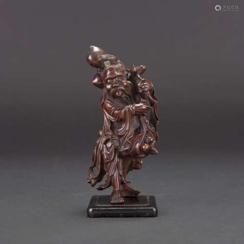 A CARVED HUANGYANG WOOD CARVING OF LONGEVITY GOD WITH