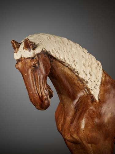 AN AMBER-GLAZED POTTERY HORSE WITH WHITE-GLAZED BRAIDED MANE...