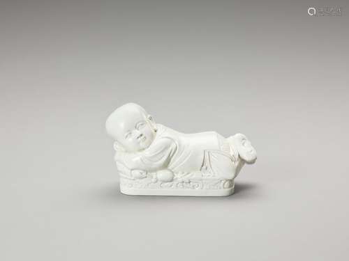 A WHITE GLAZED DEHUA PORCELAIN ‘BOY’ PILLOW, EARLY QING