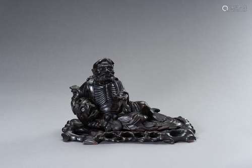 A DARK WOOD FIGURE OF BODHIDHARMA