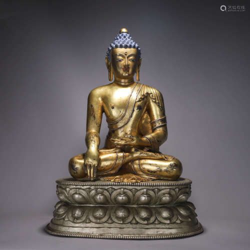 A silver buddha statue with lotus shaped pedestal
