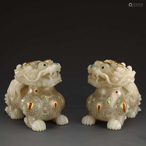 A pair of ancient white jade and gold lions