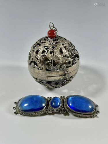 A SILVER SPHERICAL INCENSE BURNER AND A BELT BUCKLE