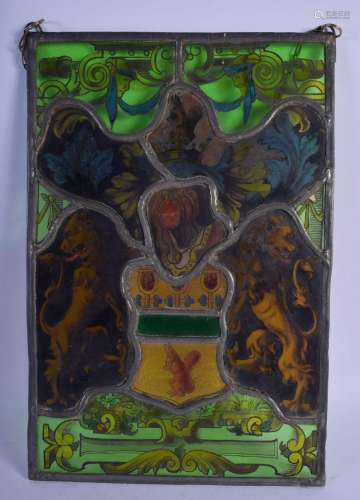 AN ANTIQUE STAINED GLASS WINDOW PANEL depicting masks, armor...