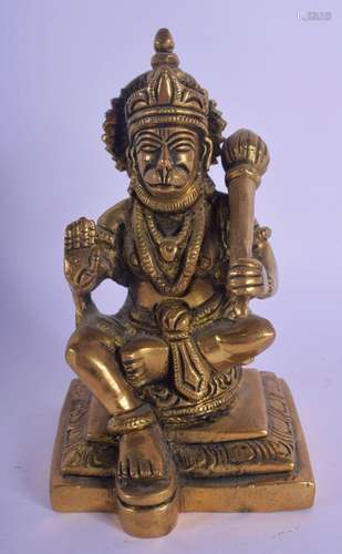 AN INDIAN BRONZE FIGURE OF A SEATED TIGER GOD modelled holdi...