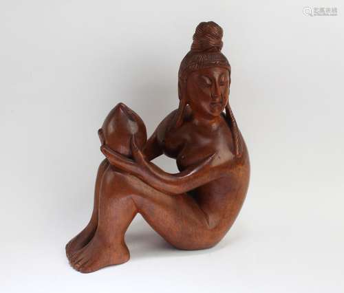 A CARVED HARDWOOD FIGURINE