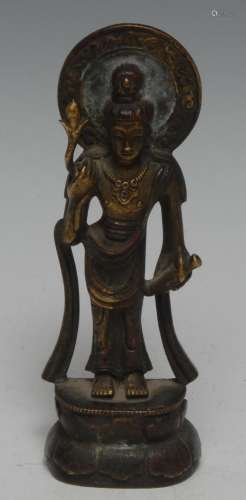A Chinese bronze figure, cast as Guanyin, she stands, holdin...