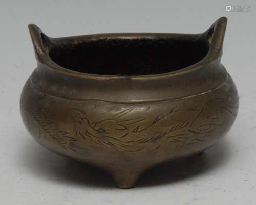 A Chinese bronze tripod censer, cast and chased with a drago...