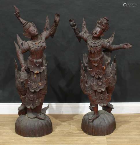 A pair of large Thai carved figures of dancers, each standin...