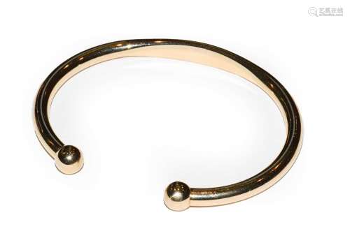 A 9 carat gold torque bangle, inner measurements 6.8cm by 5....