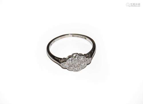 A diamond cluster ring, stamped 18CT&PLAT, finger size M...