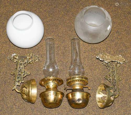 Two brass oil lamps on brackets with chimneys and shades, ca...