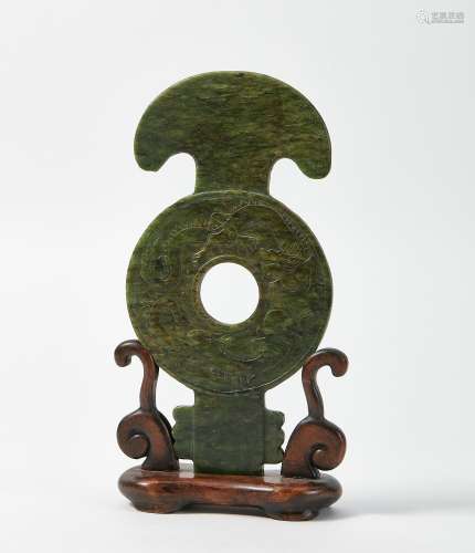 A Chinese green jade disk plaque on stand