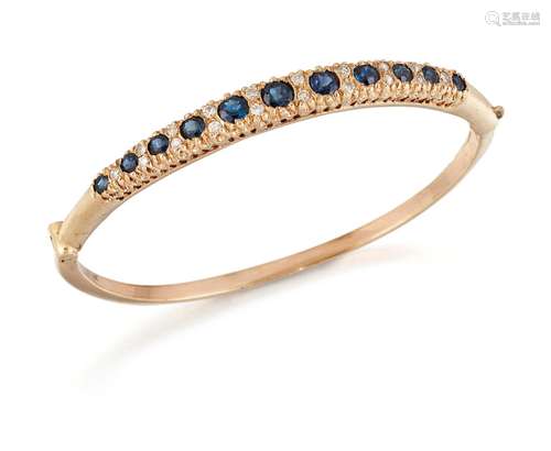 A SAPPHIRE AND DIAMOND BANGLE, graduated oval-cut sapphires ...