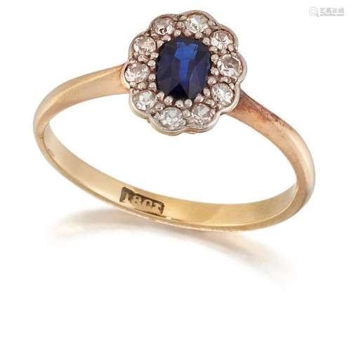 A SAPPHIRE AND DIAMOND CLUSTER RING, an oval-cut sapphire wi...