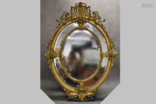 Miroir ovale à pare closes en bois et stuc sculpté et doré, ...