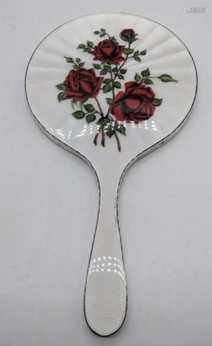 A silver hand mirror, mounted with enamel red roses on