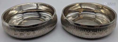 A pair of Gerald Benney silver coasters, bark effect