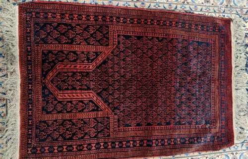 A small Persian or Turkish rug, blue and red field with