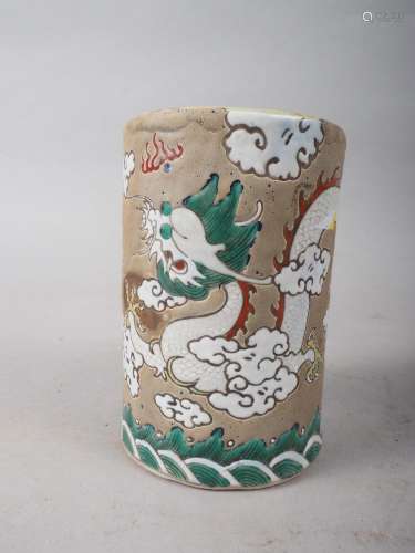 A Chinese cylindrical brush pot, decorated dragon amongst cl...