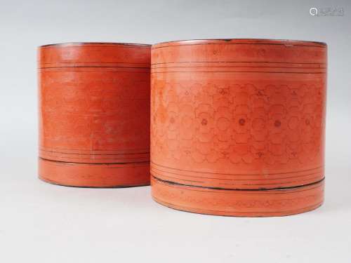 A pair of cylindrical red lacquered boxes, 7 3/4 high