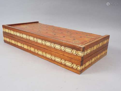 A polished as walnut and inlaid backgammon board with compos...