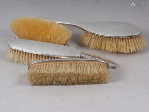 A silver four-piece brush set