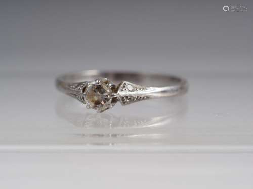 An 18ct white gold solitaire diamond ring with diamond chips...