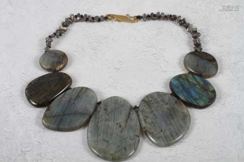 A labradorite oval disk necklace with yellow metal hook clas...