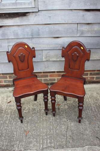 A pair of 19th century carved mahogany hall chairs with shap...