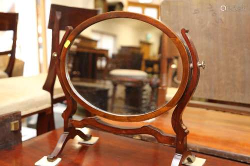 A mahogany oval swing frame toilet mirror, on splay supports...