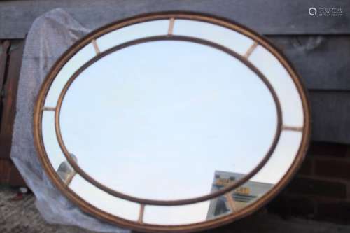 A Georgian design gilt framed oval wall mirror with sectiona...