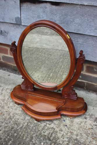 A mahogany oval swingframe toilet mirror, on plateau base, f...