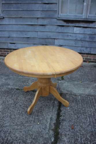 A hardwood extending oval kitchen table, on turned column an...