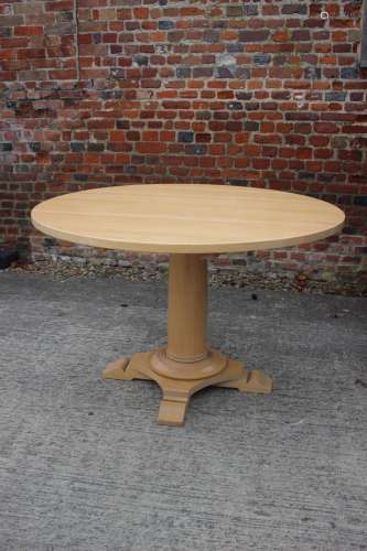 A Dan Field birch circular dining table, on turned column an...