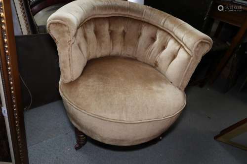 An Edwardian low seat tub armchair, button upholstered in a ...