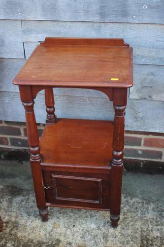 A mahogany bedside table, fitted cupboard, on turned support...