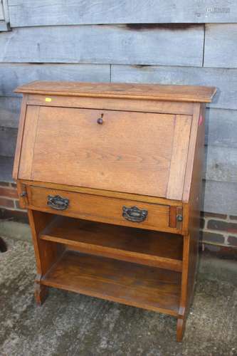 An oak fall front desk with fitted interior over one long dr...